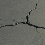 Cracked dry earth forming deep fissures.